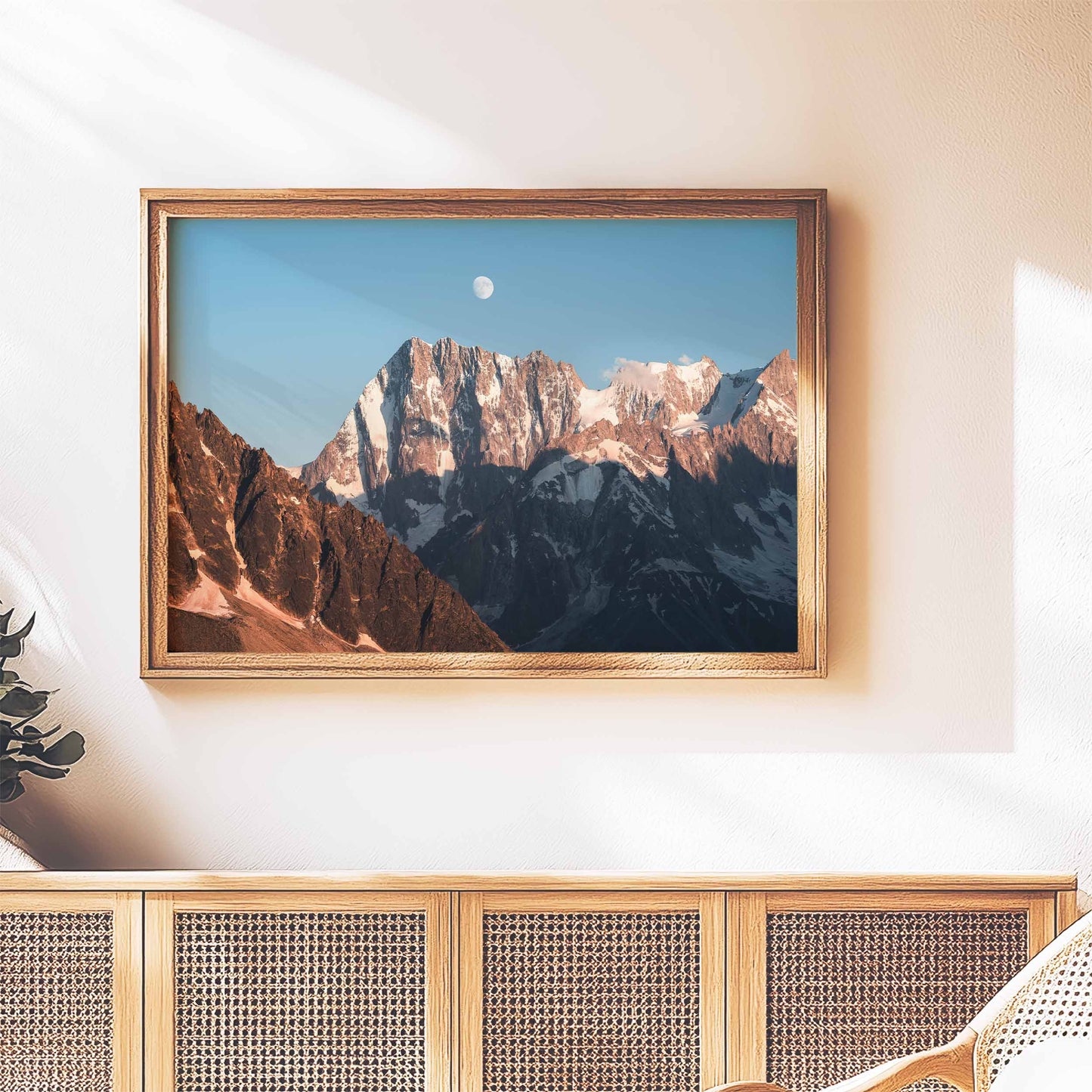 Elegant framed wall art of the Grand Jorasses in evening light, on a woven cabinet.