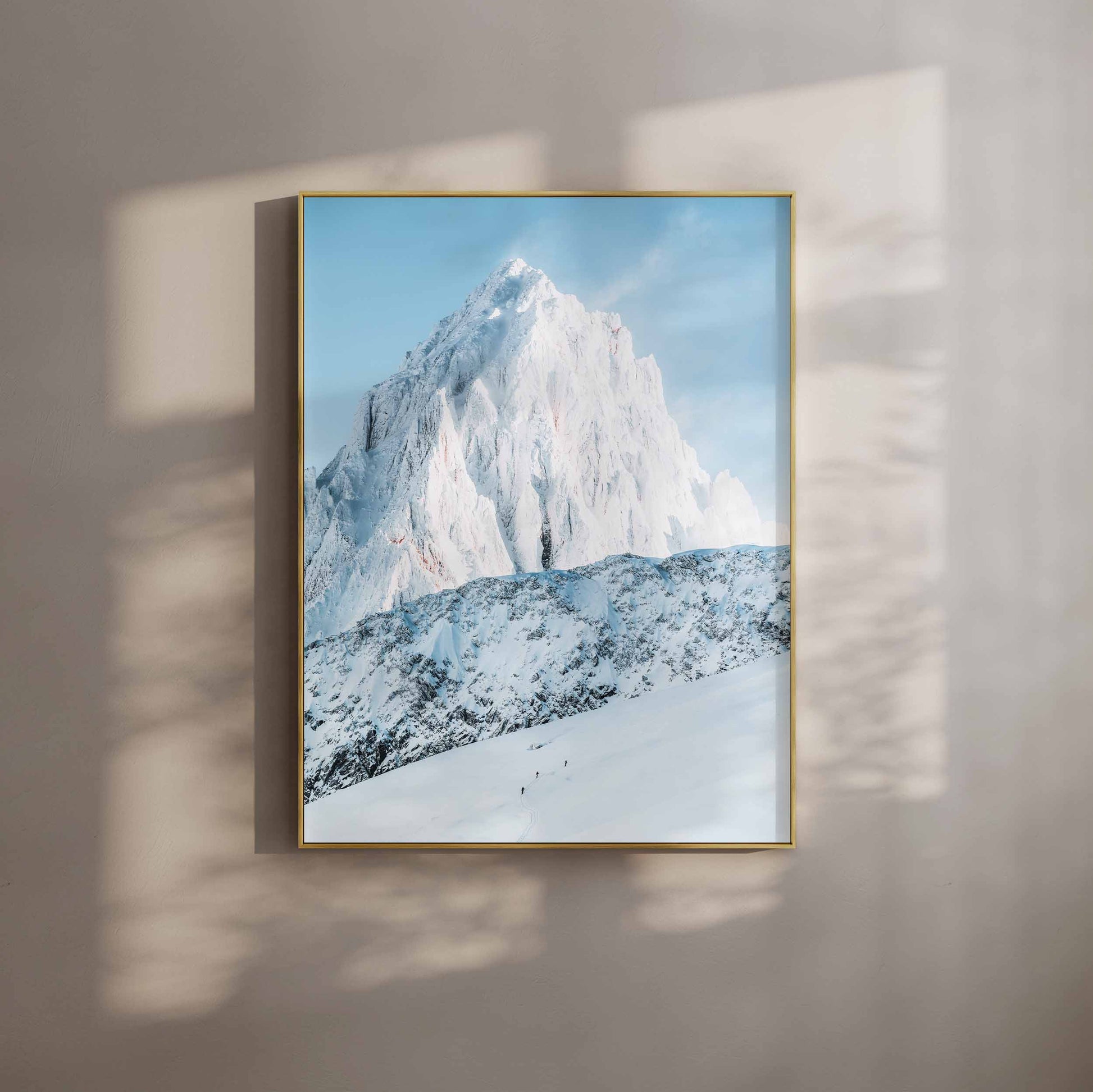 The Grand Montets peak basking in golden sunlight, surrounded by fresh snow and glaciers.