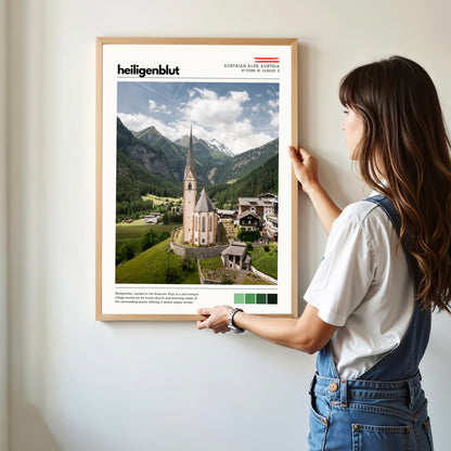 Person hanging a Heiligenblut Austrian Alps location poster in a modern home interior