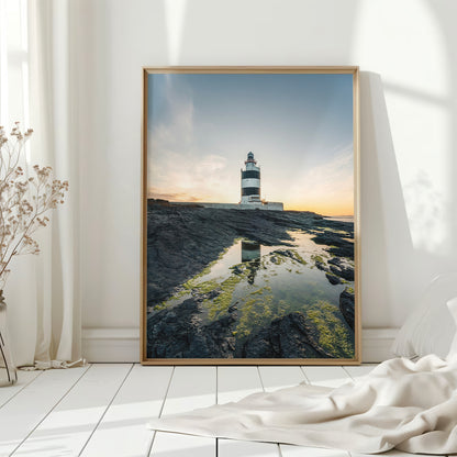 Framed Irish lighthouse print by a white wall with natural light and floor decor