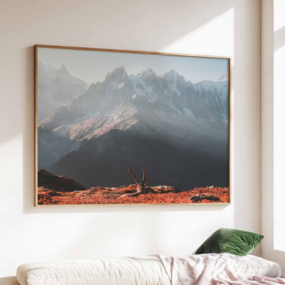 Wall art of an ibex basking in sunrise light against Mont Blanc, displayed above a sofa.