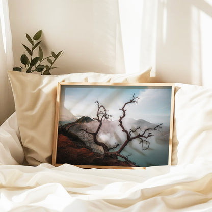Ijen volcano dead tree framing turquoise crater lake framed print in natural wood frame leaning against pillow on white bed