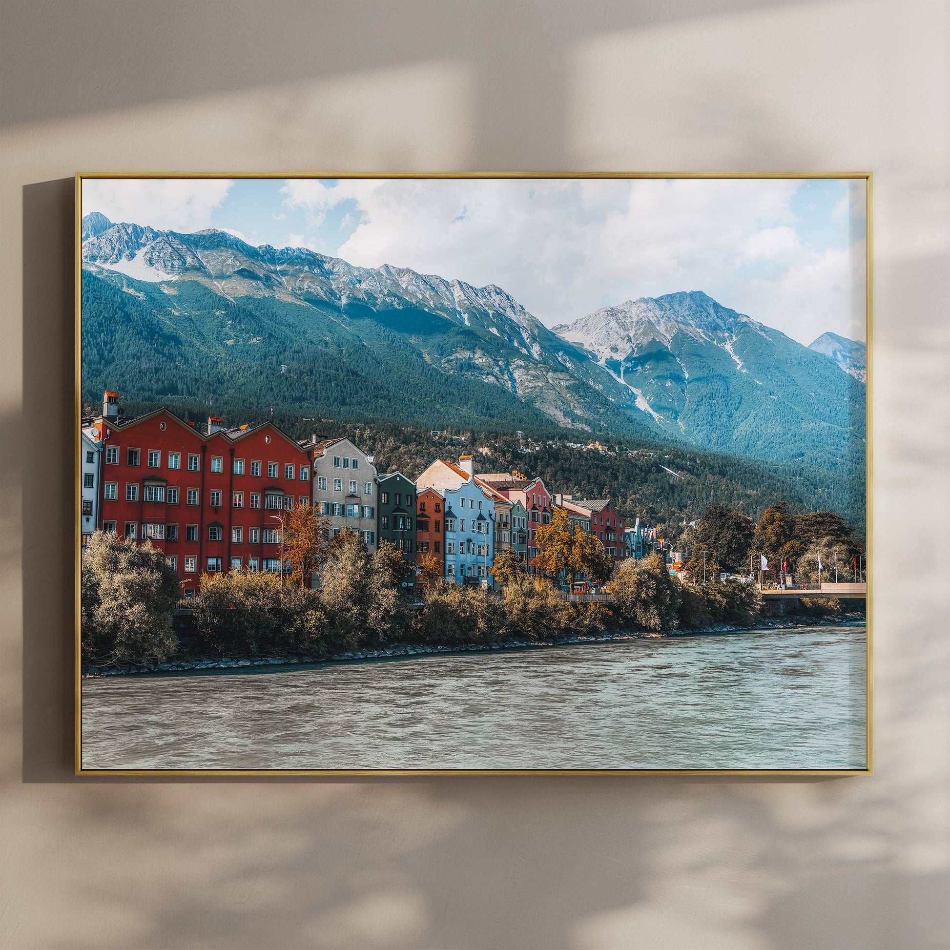 Fine art wall print of Innsbruck's colourful houses along the river with mountain backdrop.