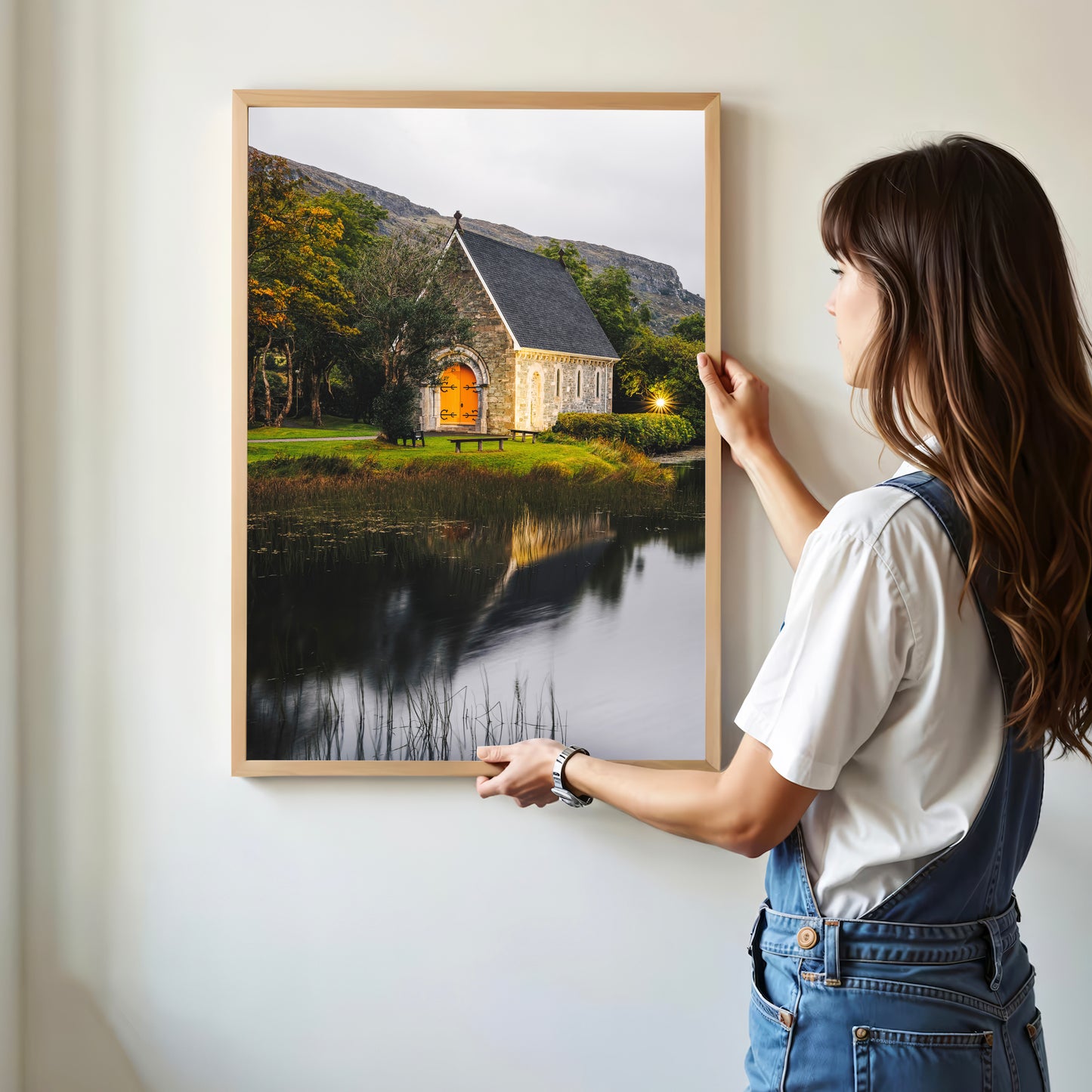 Woman holding Irish church landscape print in a minimal interior