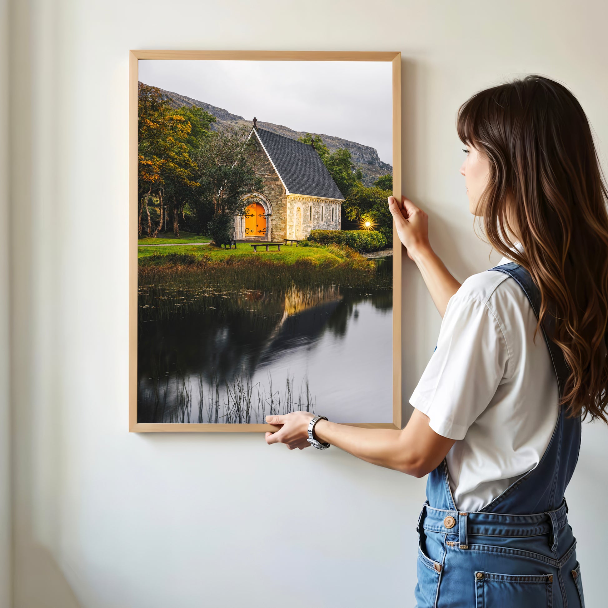 Woman holding Irish church landscape print in a minimal interior