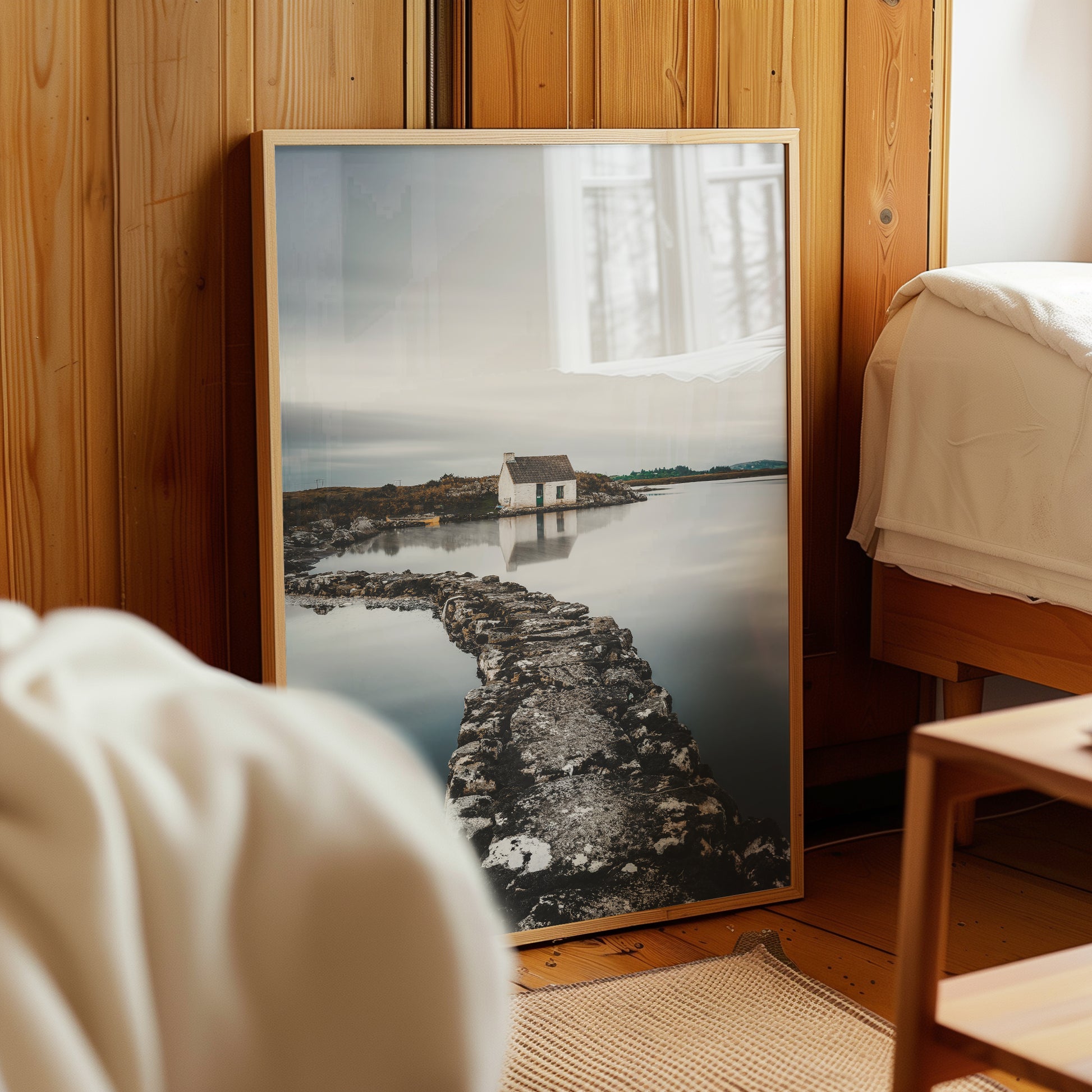Framed bothy wall art leaning against wooden wall in rustic bedroom