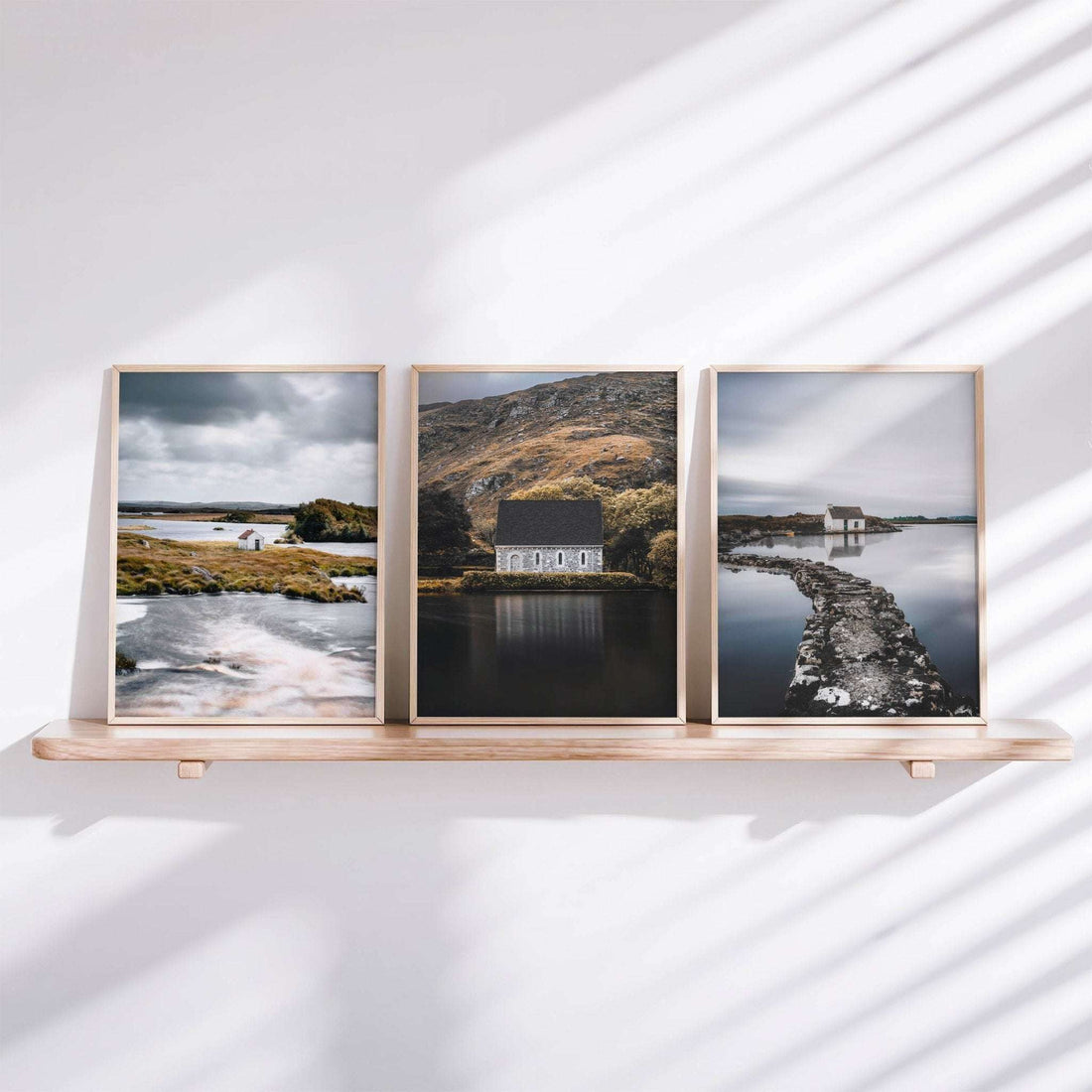Set of three Irish landscape prints styled on a shelf, featuring a Connemara hut, Gougane Barra, and a fisherman’s bothy