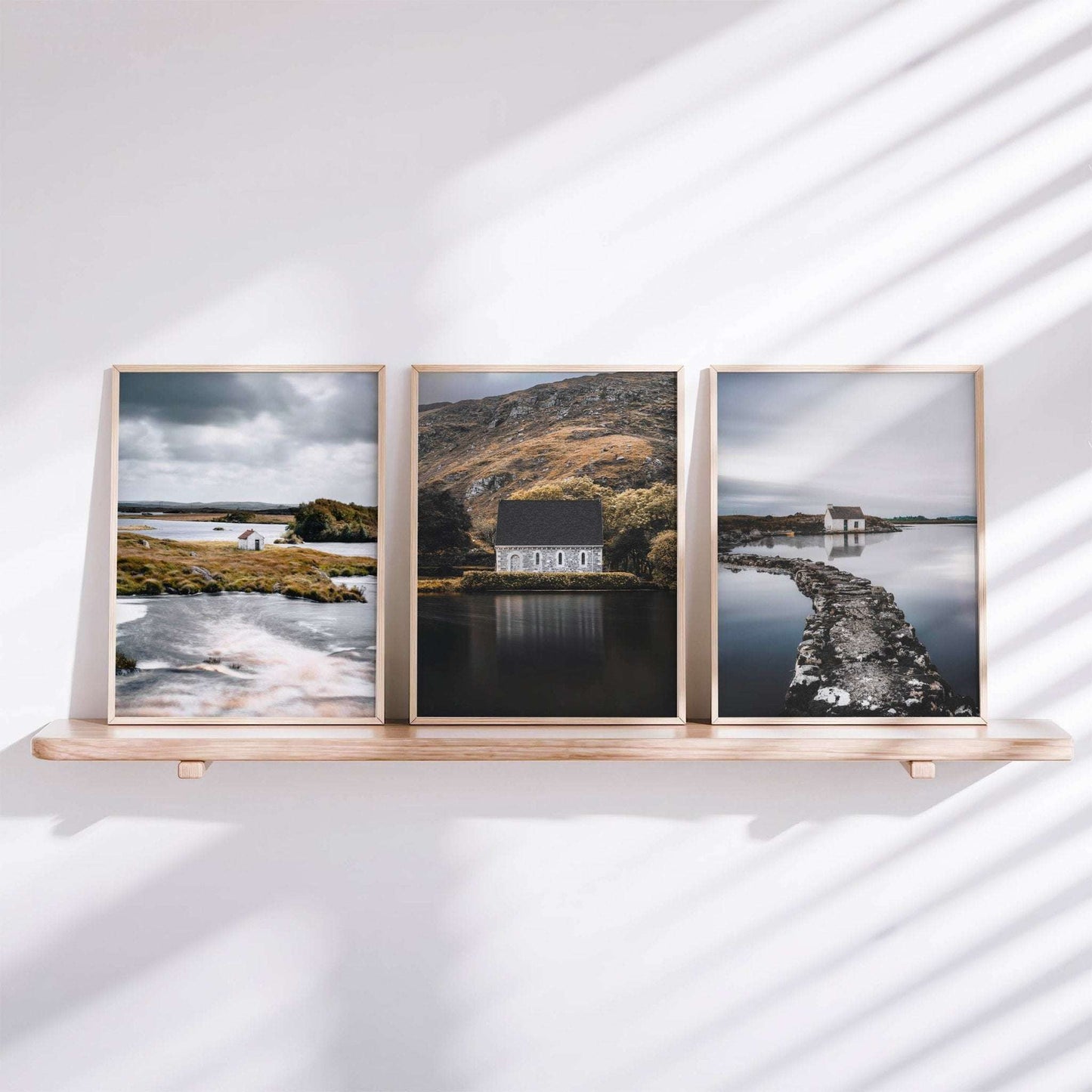 Set of three Irish landscape prints styled on a shelf, featuring a Connemara hut, Gougane Barra, and a fisherman’s bothy