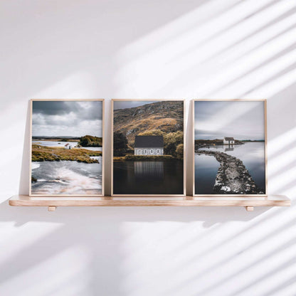 Set of three Irish landscape prints styled on a shelf, featuring a Connemara hut, Gougane Barra, and a fisherman’s bothy
