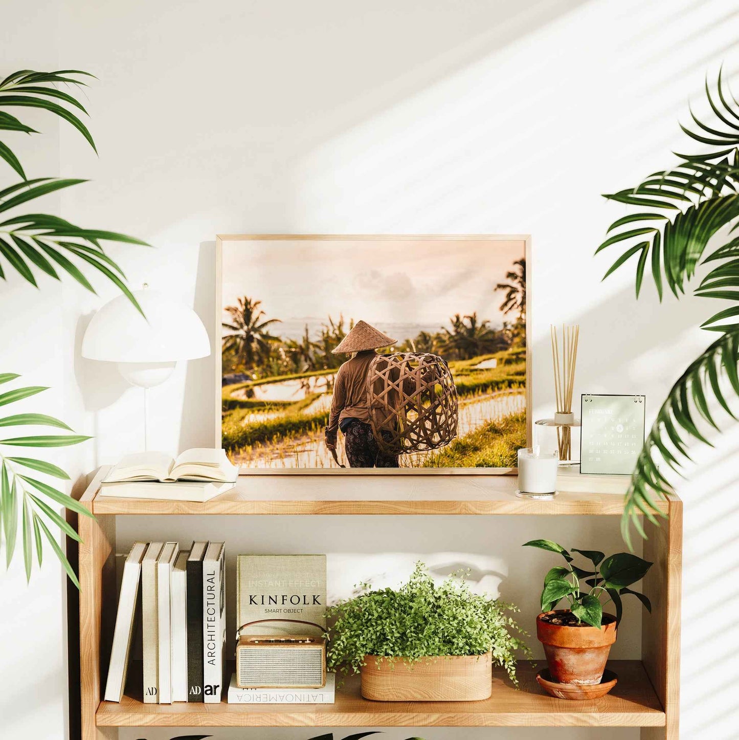 Framed Jatiluwih Rice Terraces Bali farmer print styled on a bookshelf in a bright living room interior