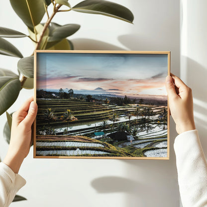 Person holding a natural wood framed sunrise print of Jatiluwih Rice Terraces Bali Indonesia