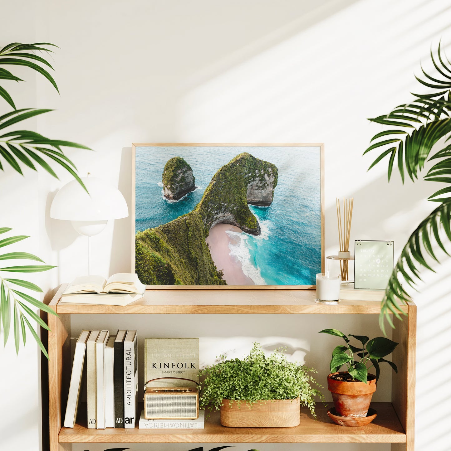 Framed Kelingking Beach Nusa Penida Bali aerial print styled on a bookshelf in a bright living room interior