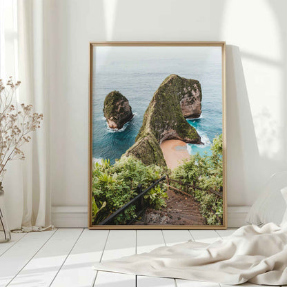 Kelingking Beach Nusa Penida large framed wall art print in natural wood frame leaning against white wall with dried flowers