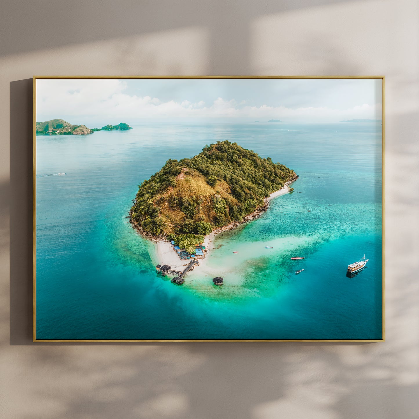 Framed aerial print of Kelor Island Komodo in a gold float frame mounted on a wall