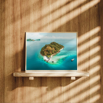 Natural wood framed Kelor Island Komodo aerial print displayed on a wooden shelf