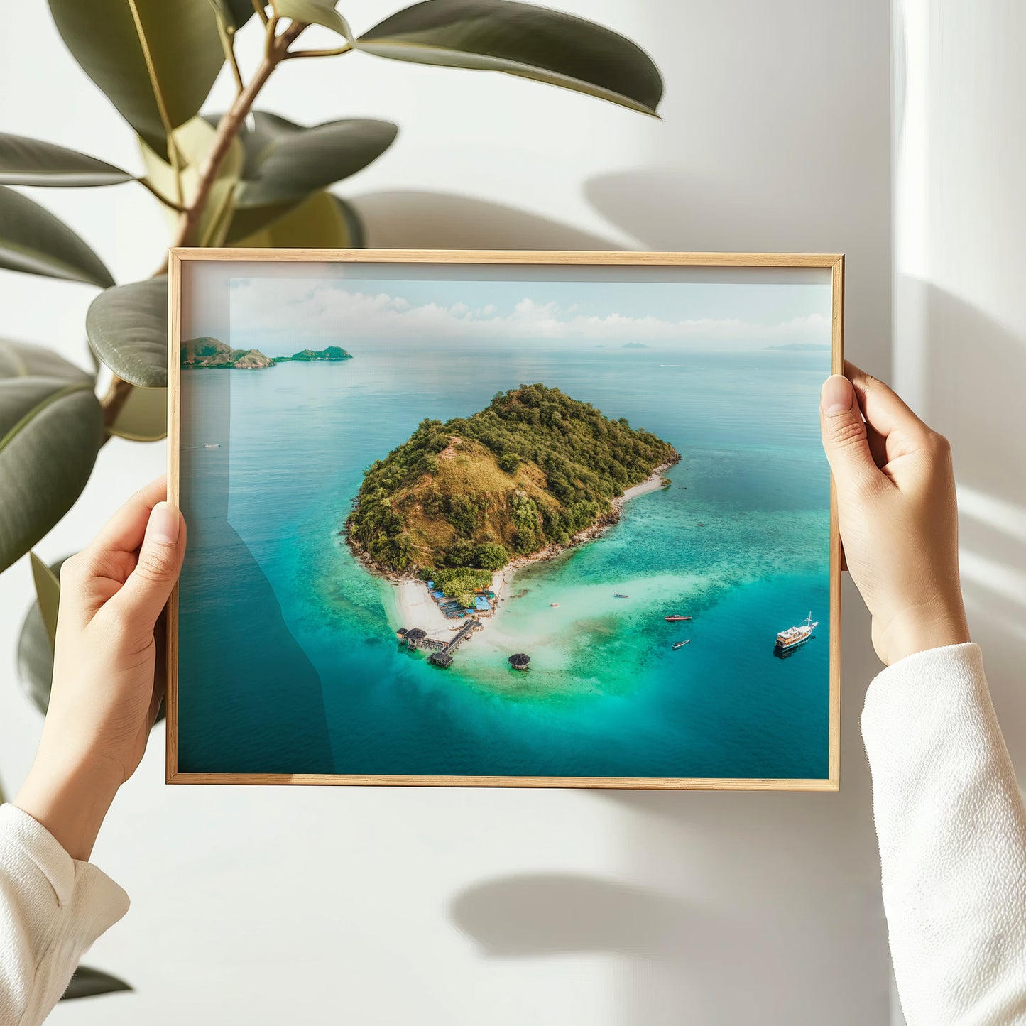 Person holding a natural wood framed print of Kelor Island Komodo aerial drone photo