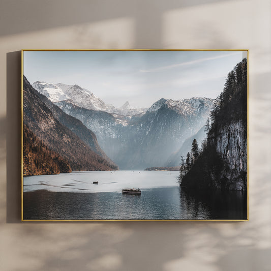 Boats on Königssee lake with alpine cliffs and snowy mountains in Bavaria