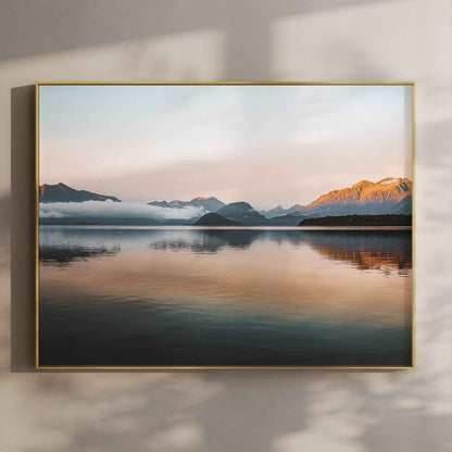 Lake Manapouri New Zealand photography print in gold float frame mounted on warm beige wall with window light shadows