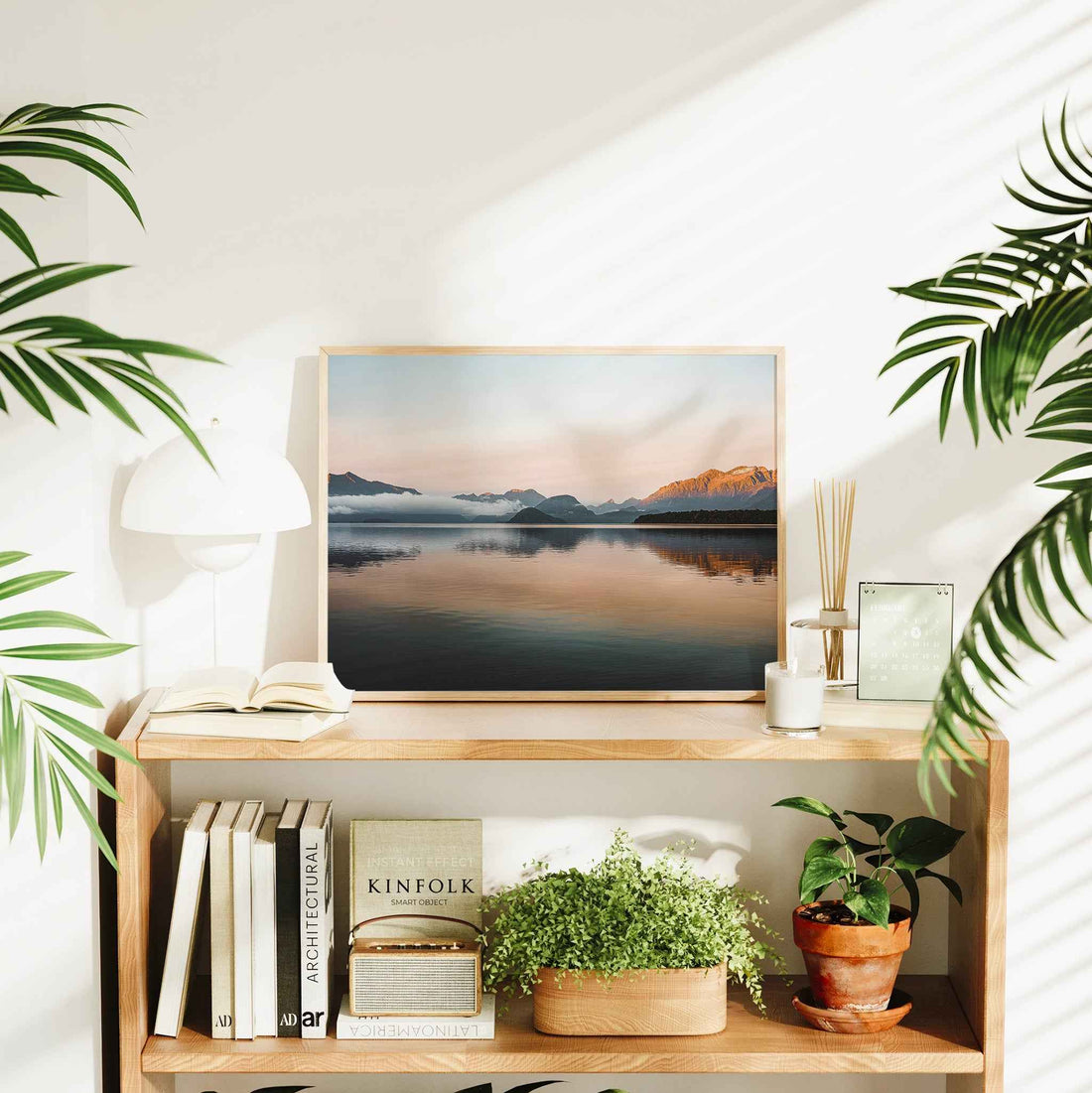 Lake Manapouri New Zealand photography print in natural wood frame displayed on timber bookshelf in bright Scandi living room