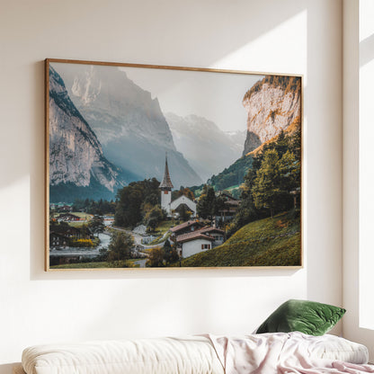 Framed Lauterbrunnen print styled above a sofa, showcasing an alpine village in the Swiss Alps.