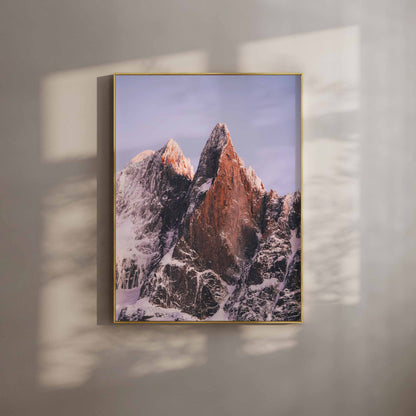 Snow-covered Les Drus peaks illuminated by golden light at sunset in the French Alps.