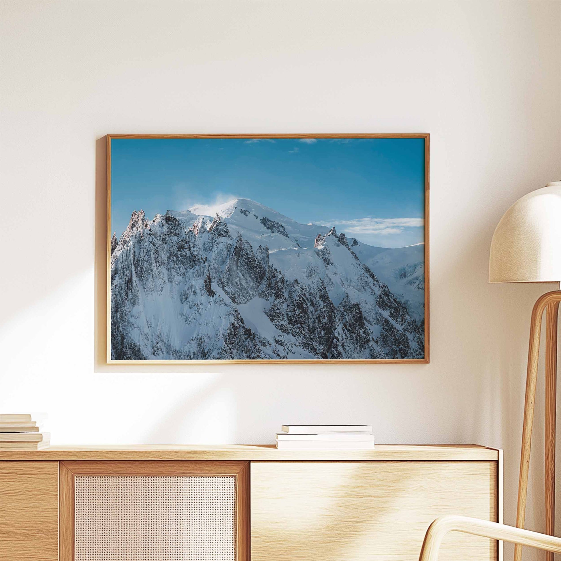 Massif du Mont Blanc framed wall art styled on a modern wooden cabinet with books and a lamp.