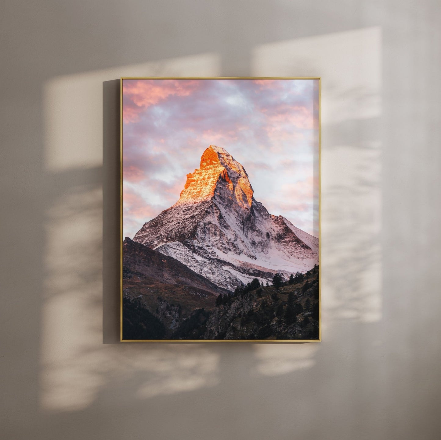 The Matterhorn in warm alpenglow light, framed in gold, with vibrant pink and orange clouds