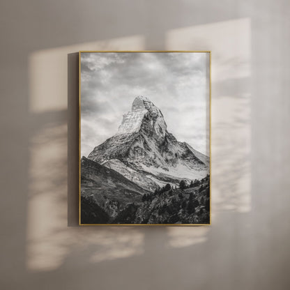 Black and white photo of the Matterhorn in a gold frame on a beige wall with soft light.