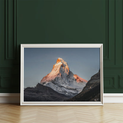 Matterhorn mountain print with a sunrise glow, framed against a deep green wall.