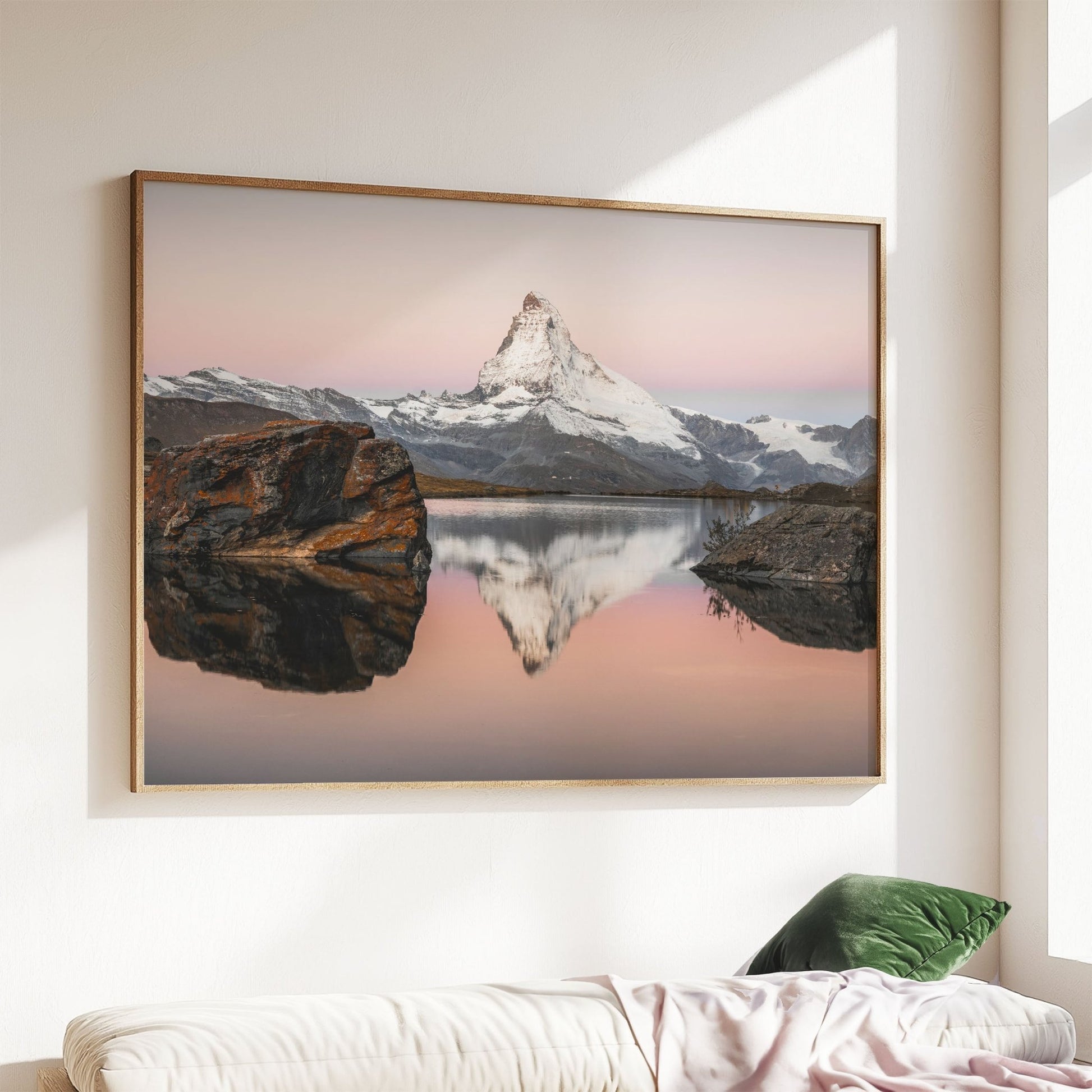 The Matterhorn glowing in soft pink tones at sunset, mirrored in Stellisee lake.