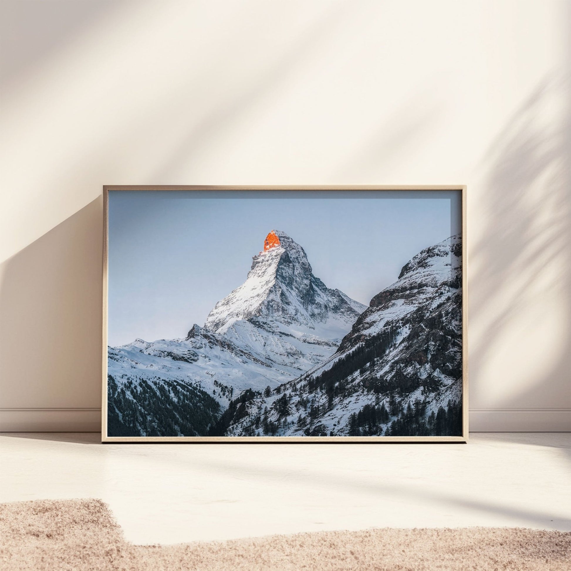 Stunning Matterhorn mountain glowing in warm sunset light, surrounded by snow.