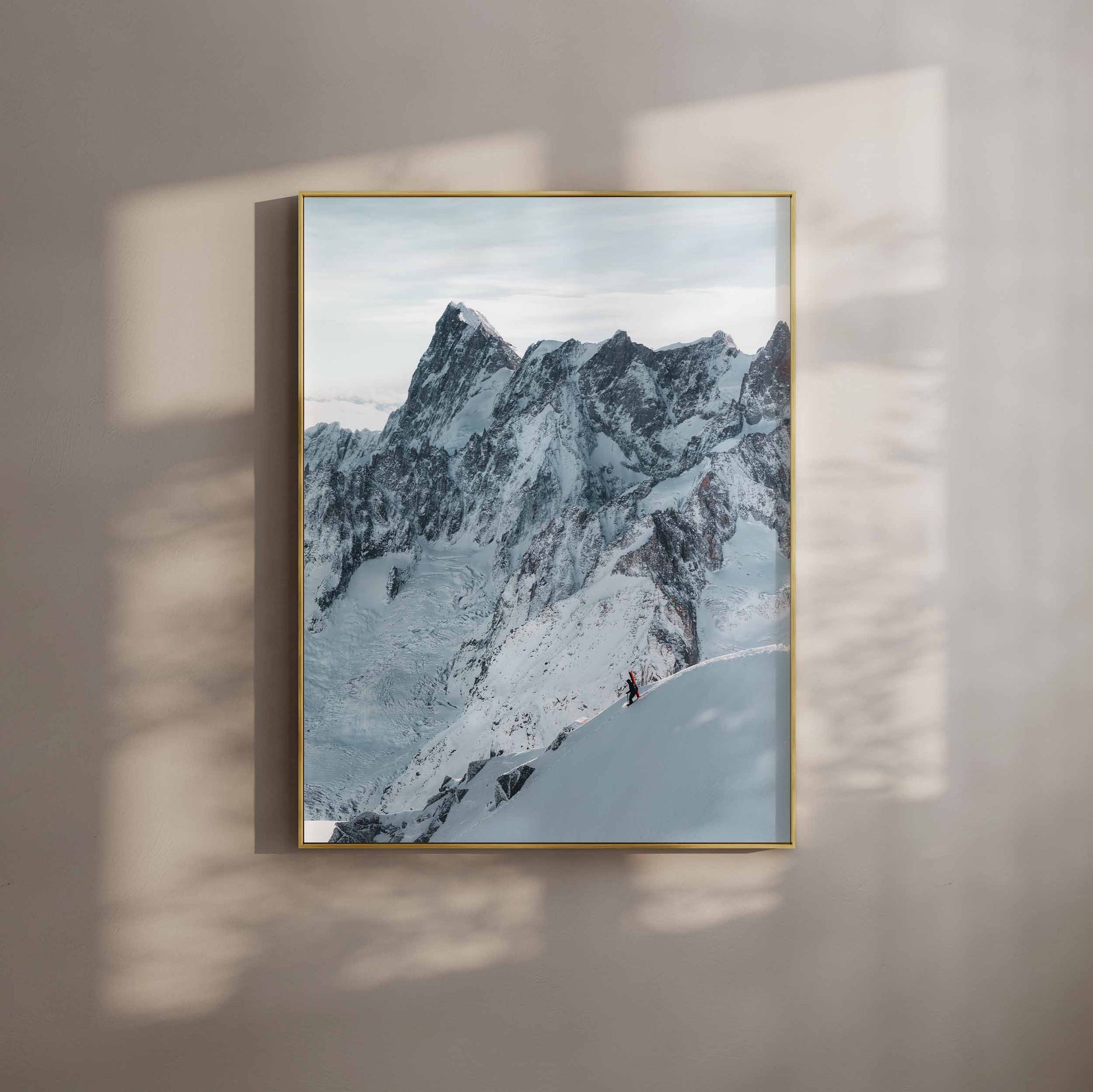 A skier descending the Midi Arete in front of dramatic snow-covered peaks, wall art in a modern gold frame.