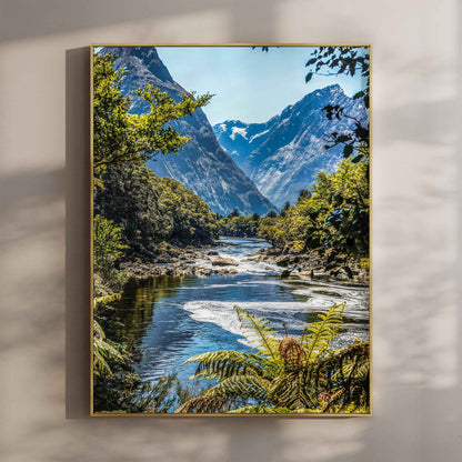 Framed print of Milford Track Fiordland New Zealand river and mountains in a gold float frame mounted on a wall