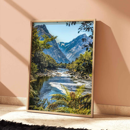 Natural wood framed Milford Track Fiordland New Zealand print leaning against a terracotta wall