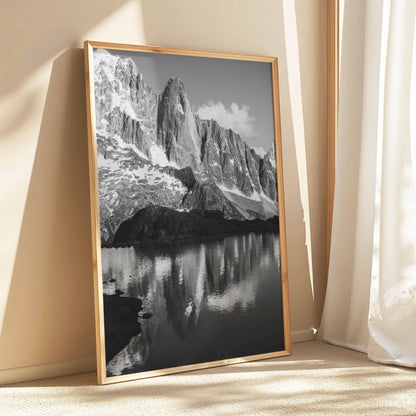 Minimalist black and white photography of Les Drus mountain mirrored in an alpine lake.