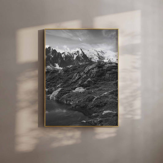 Framed black-and-white photo of Mont Blanc and alpine scenery, with serene reflections of the peaks in a rustic, cozy setting.