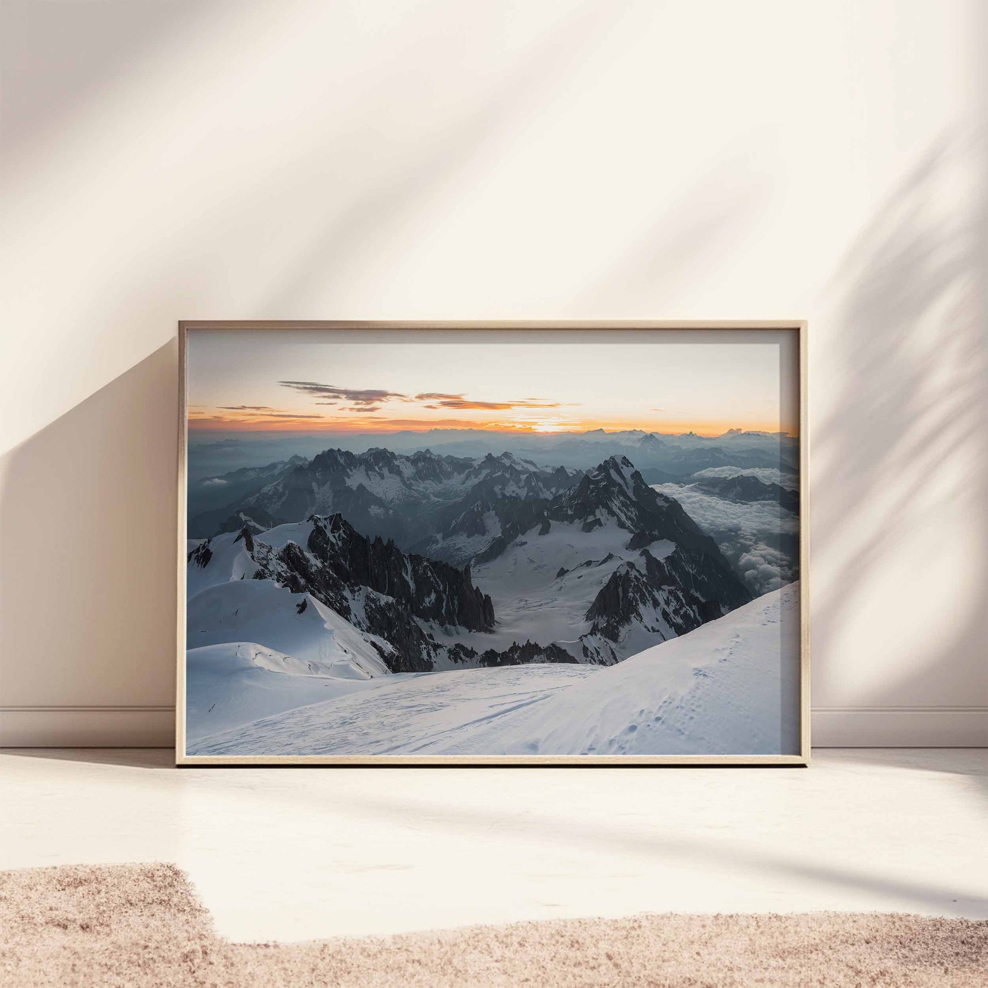 Bright and airy room with framed Mont Blanc summit wall art leaning on a floor