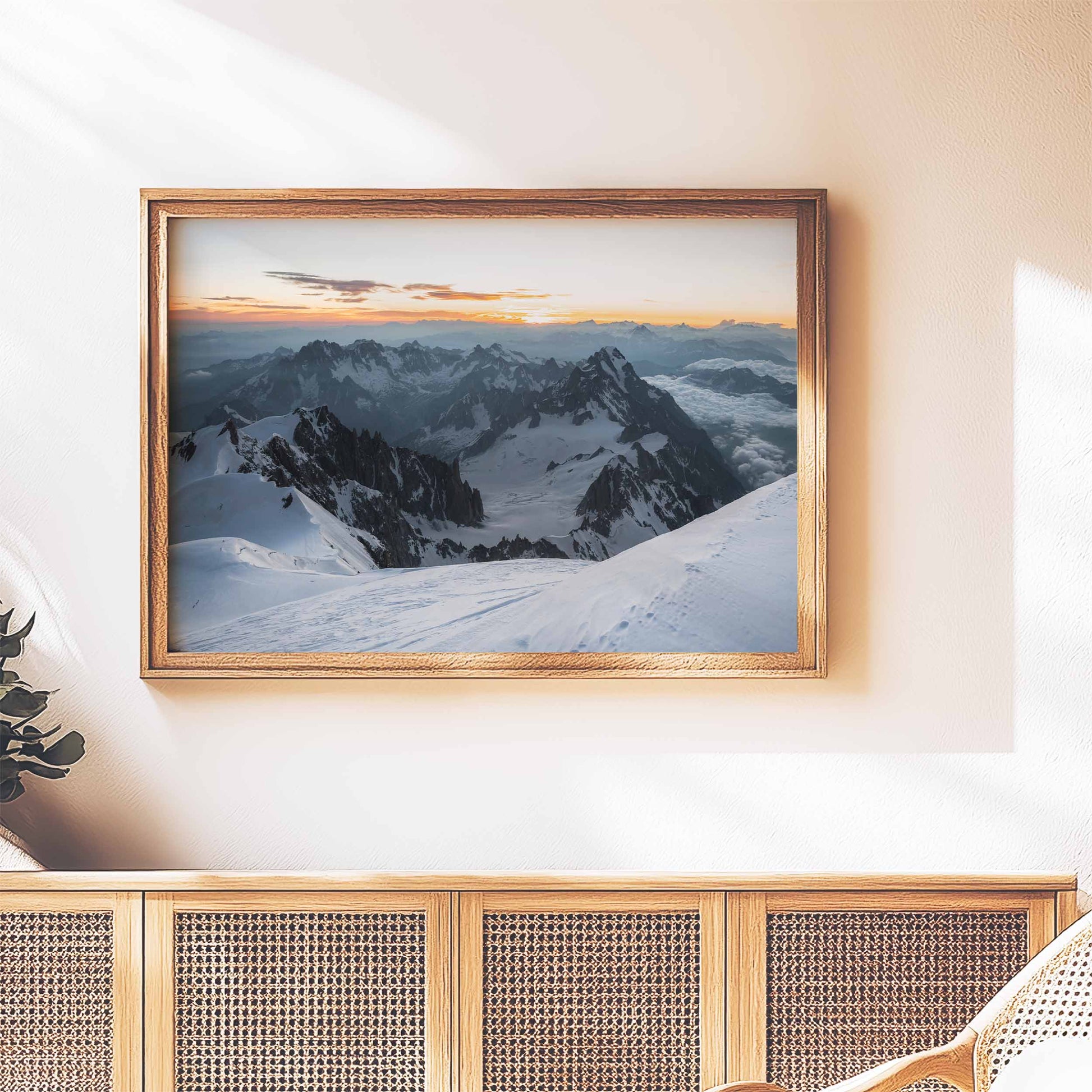 Warm-toned Mont Blanc summit wall art displayed above a wicker cabinet