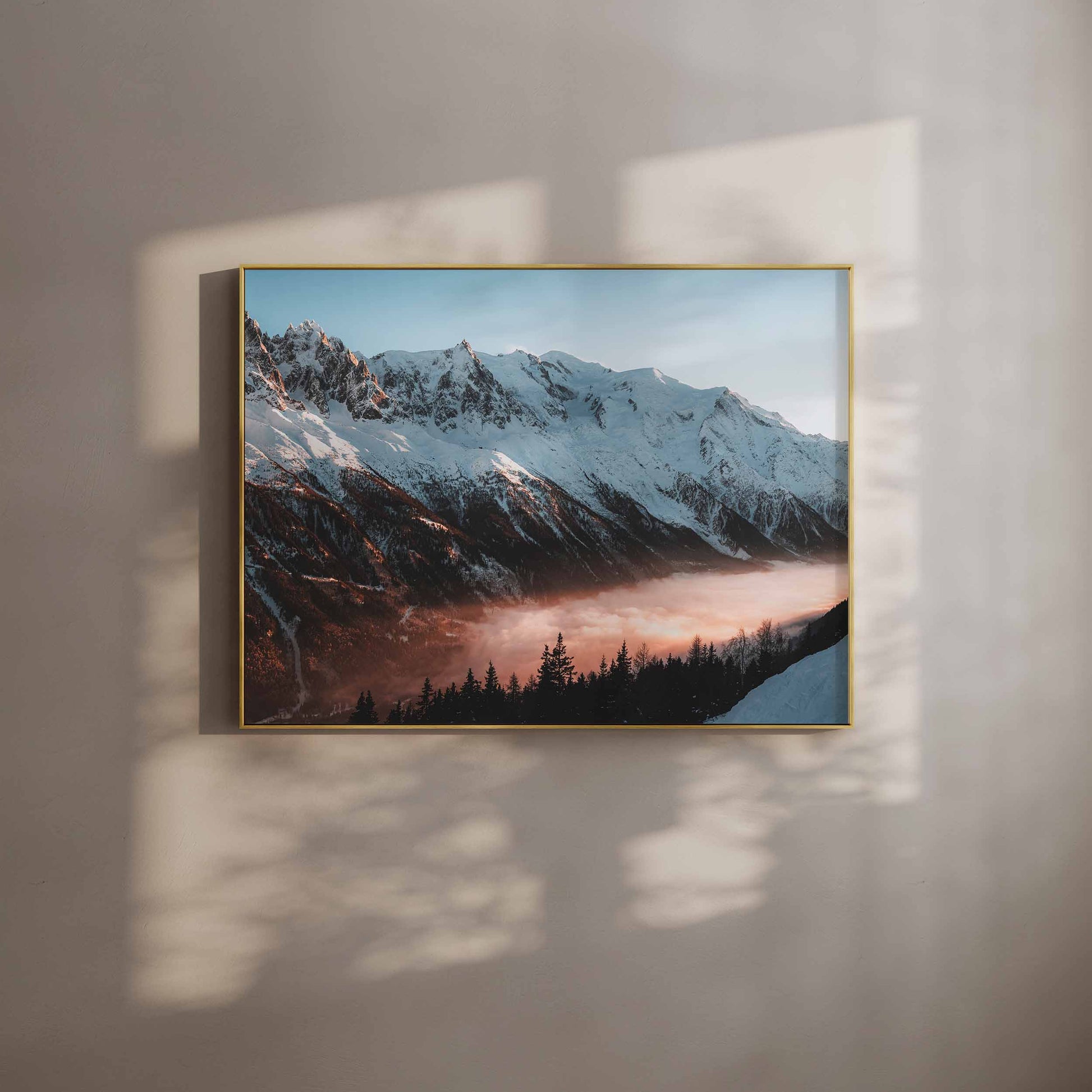 Golden sunset view of Mont Blanc massif captured in a stylish gold frame on a textured wall.