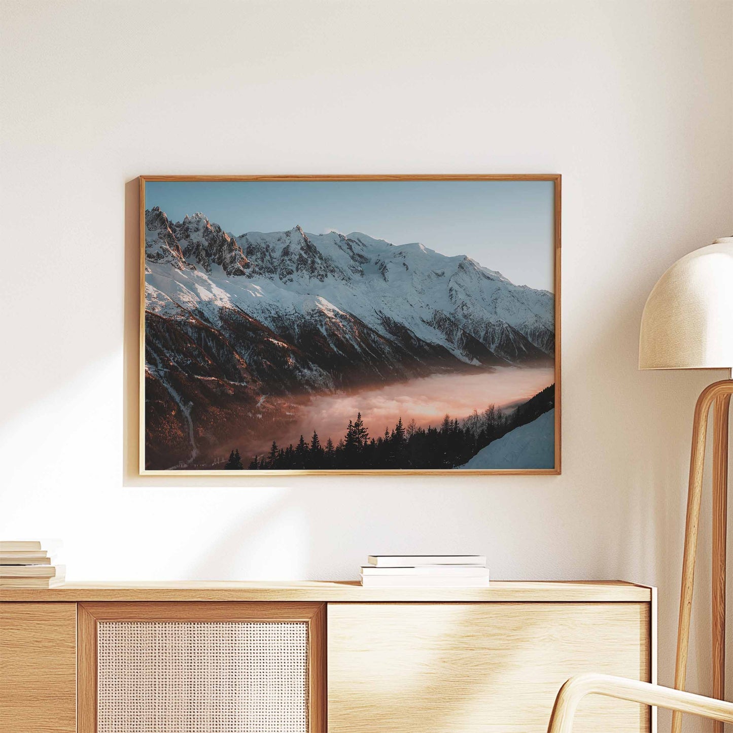 Sunset Mont Blanc massif wall art framed in a natural wood finish above a minimalist console table.