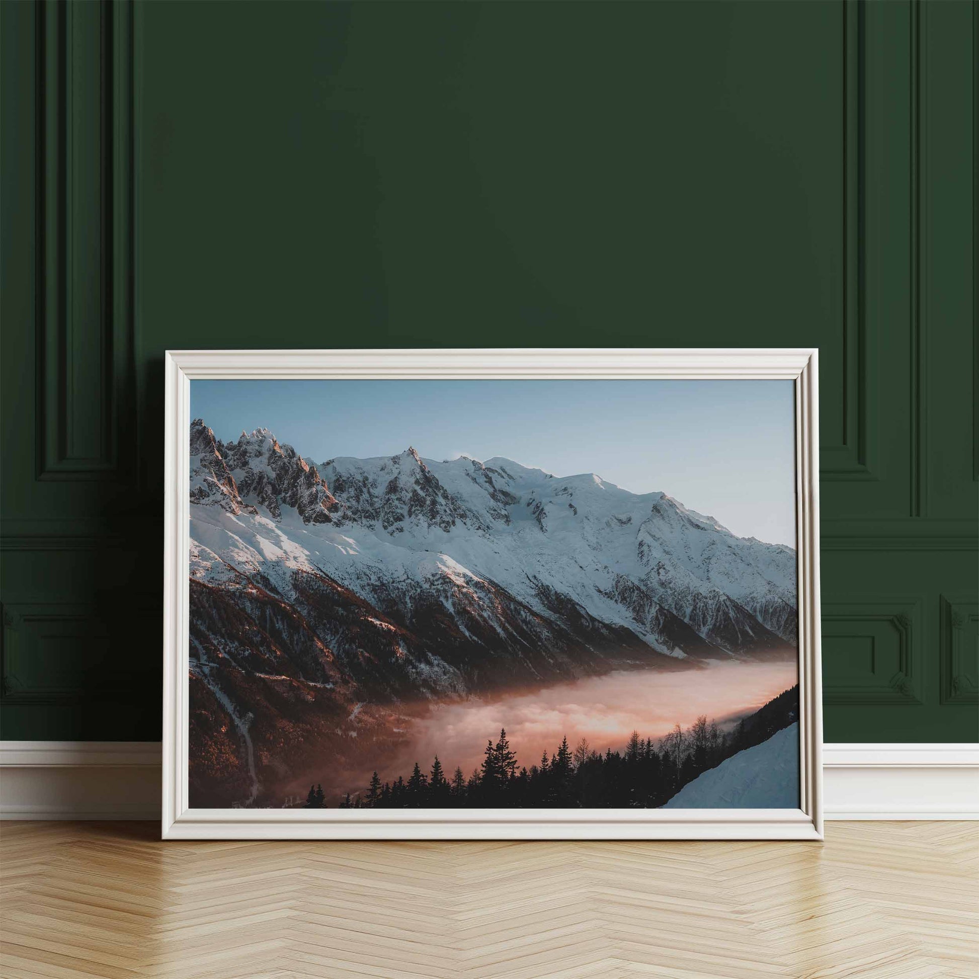 Mont Blanc massif sunset artwork leaning in a white frame against a dark green wall.