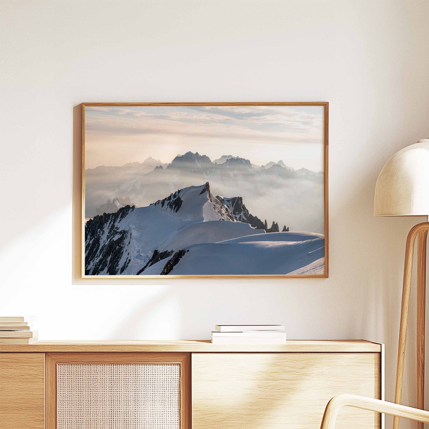 Mont Maudit summit framed wall art displayed above a wooden sideboard with books.