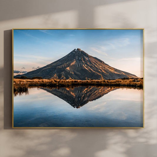 Mount Taranaki volcano reflection tarn photography print in gold float frame mounted on warm beige wall with window light shadows