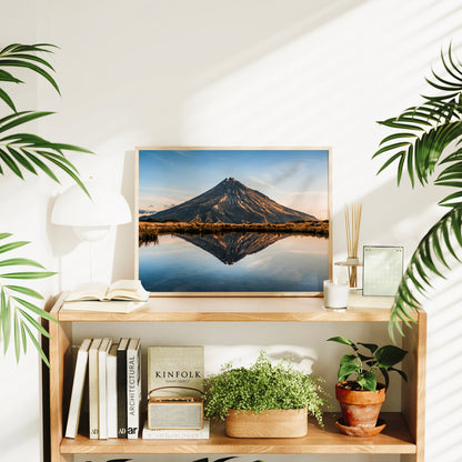 Mount Taranaki reflection tarn photography print in natural wood frame displayed on timber bookshelf in bright Scandi living room
