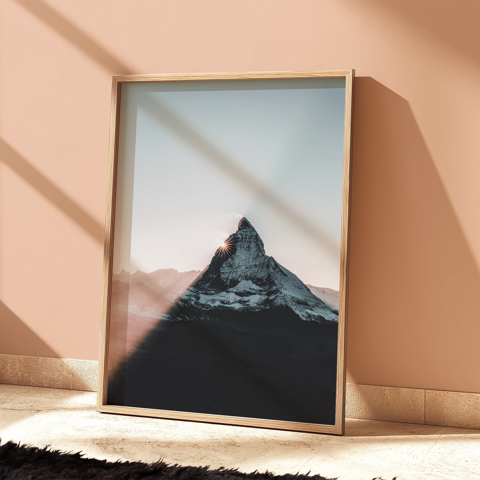 Matterhorn wall art leaning against peach wall with bold shadow line