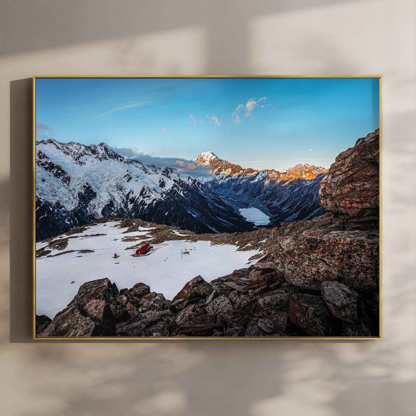 Mueller Hut and Mount Cook National Park photography print in gold float frame mounted on warm beige wall with window light shadows