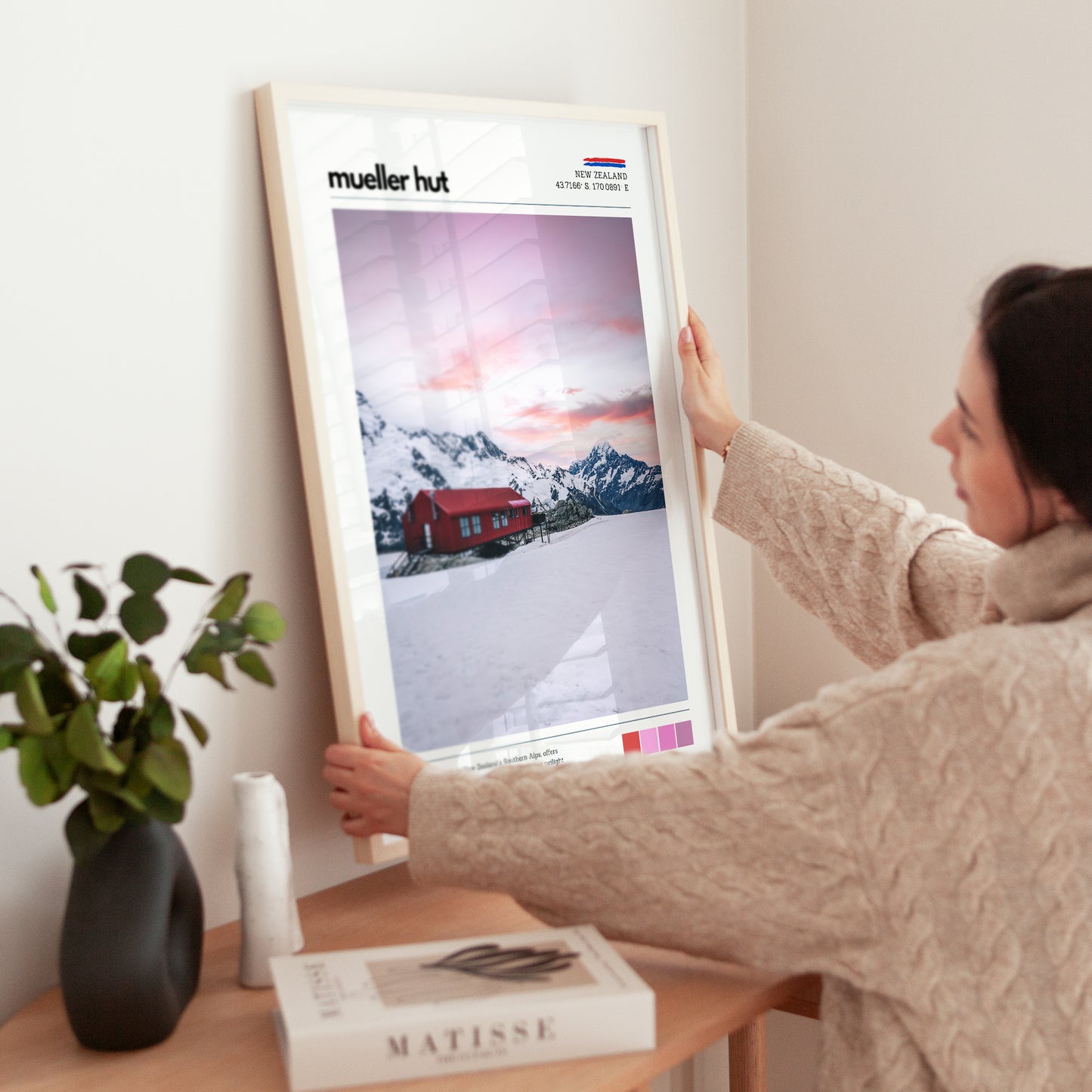 Close-up of Mueller Hut wall art print being held, showing sunrise colours and snowy alpine landscape