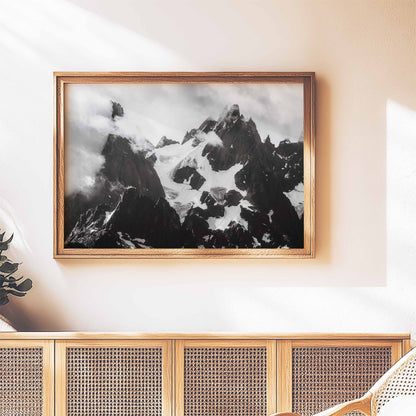 Framed black-and-white artwork of the Needles of Chamonix above a wooden console with woven detailing