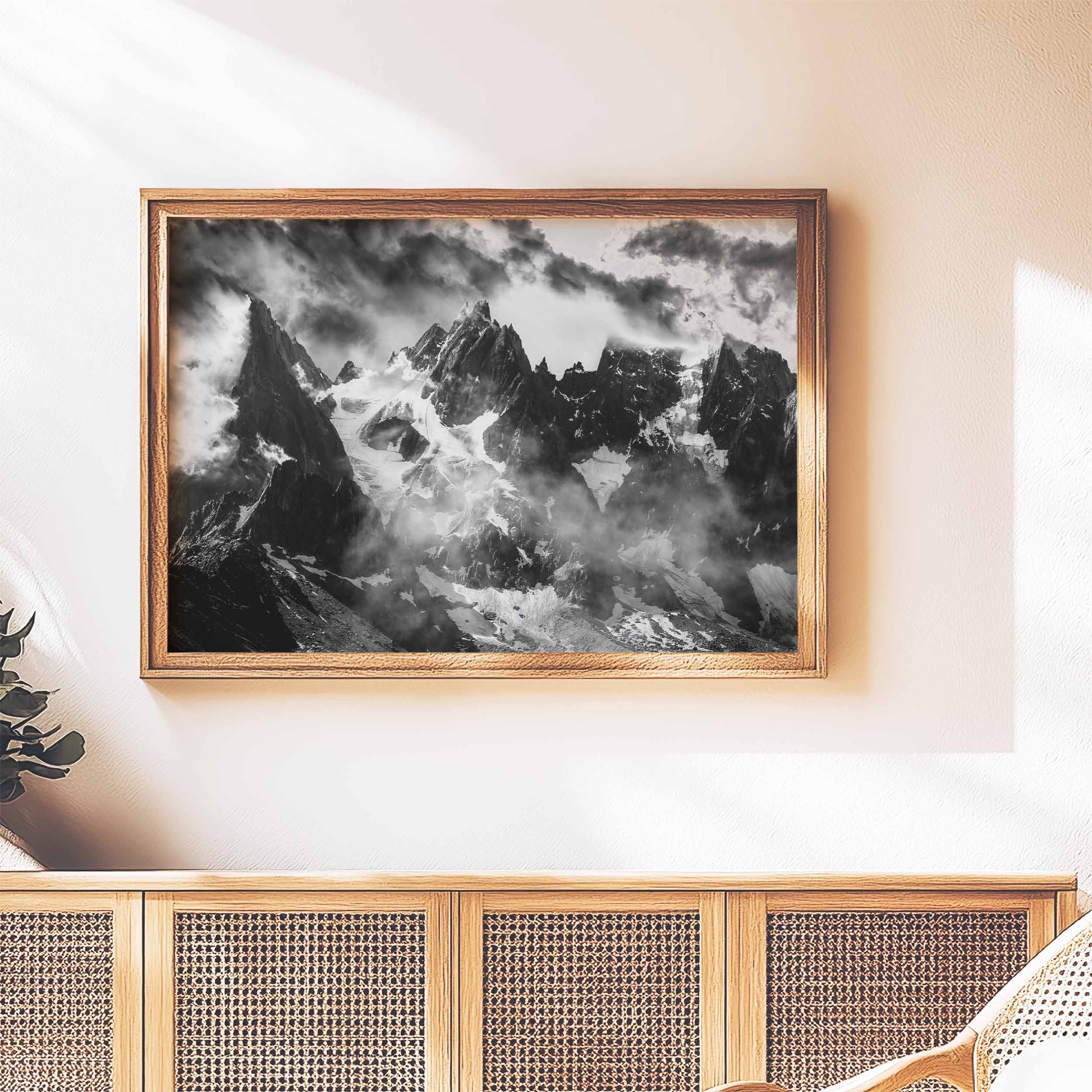 Stylish black and white print of the Chamonix Needles, featuring rugged alpine peaks and mist, in a cozy, well-lit room.