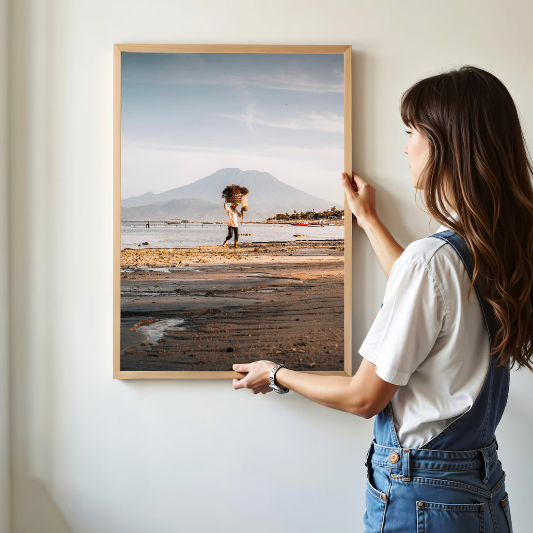 Woman hanging Nusa Lembongan seaweed farmer framed art print with Mount Agung in natural oak wood frame on white wall